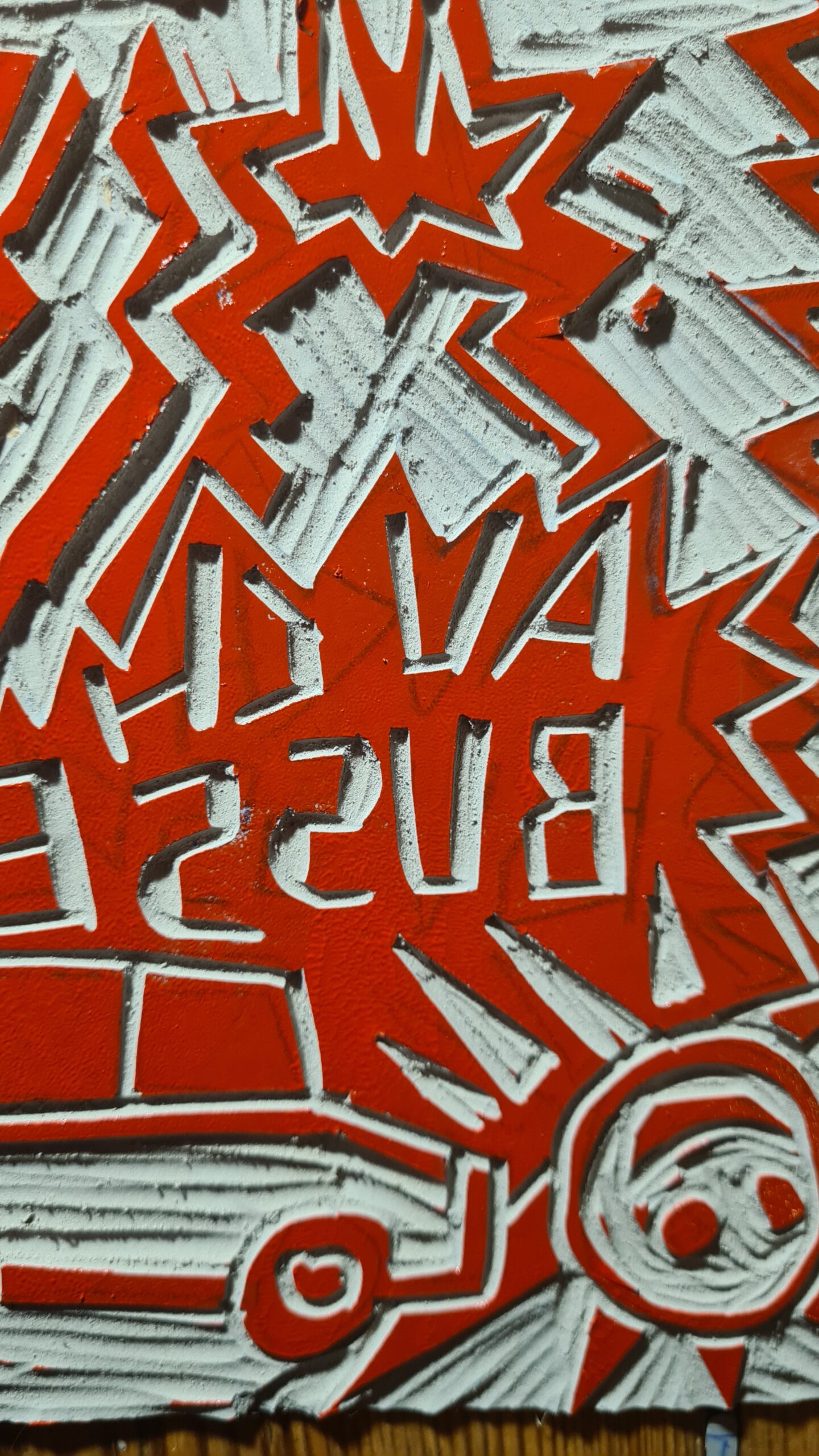 A closeup of a pointy wyld linocut with red ink on it.